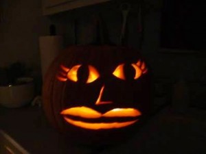 Glowing carved pumpkin or jack-o-lantern sitting on a dark kitchen counter